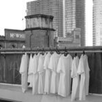 white t-shirts hanging on a rack in a city
